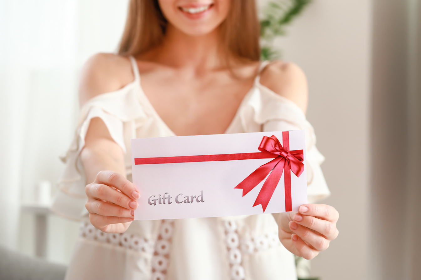 Beautiful Young Woman with Gift Card at Home